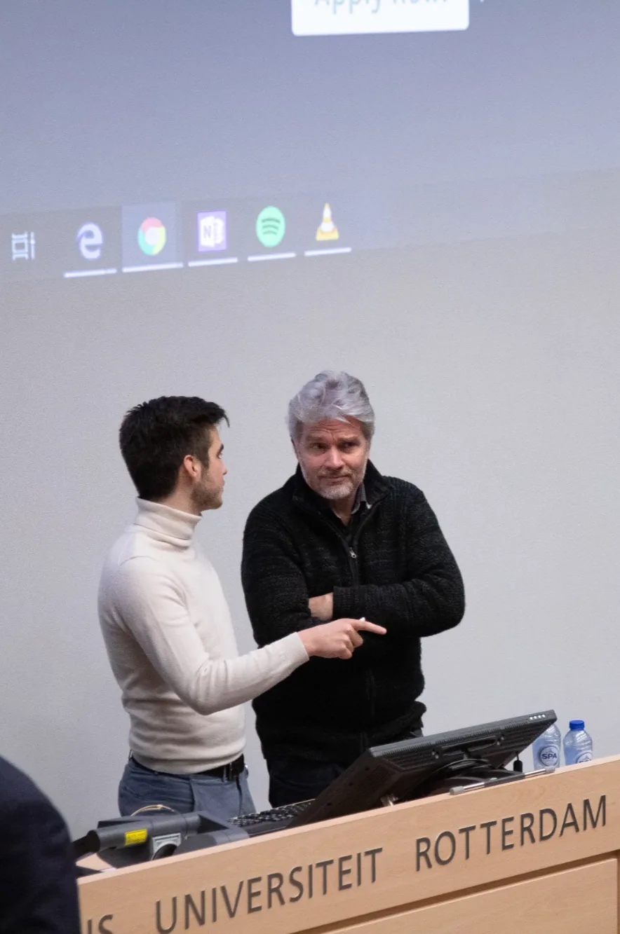 Magnus van Haaren speaking with a guest at a university lectern